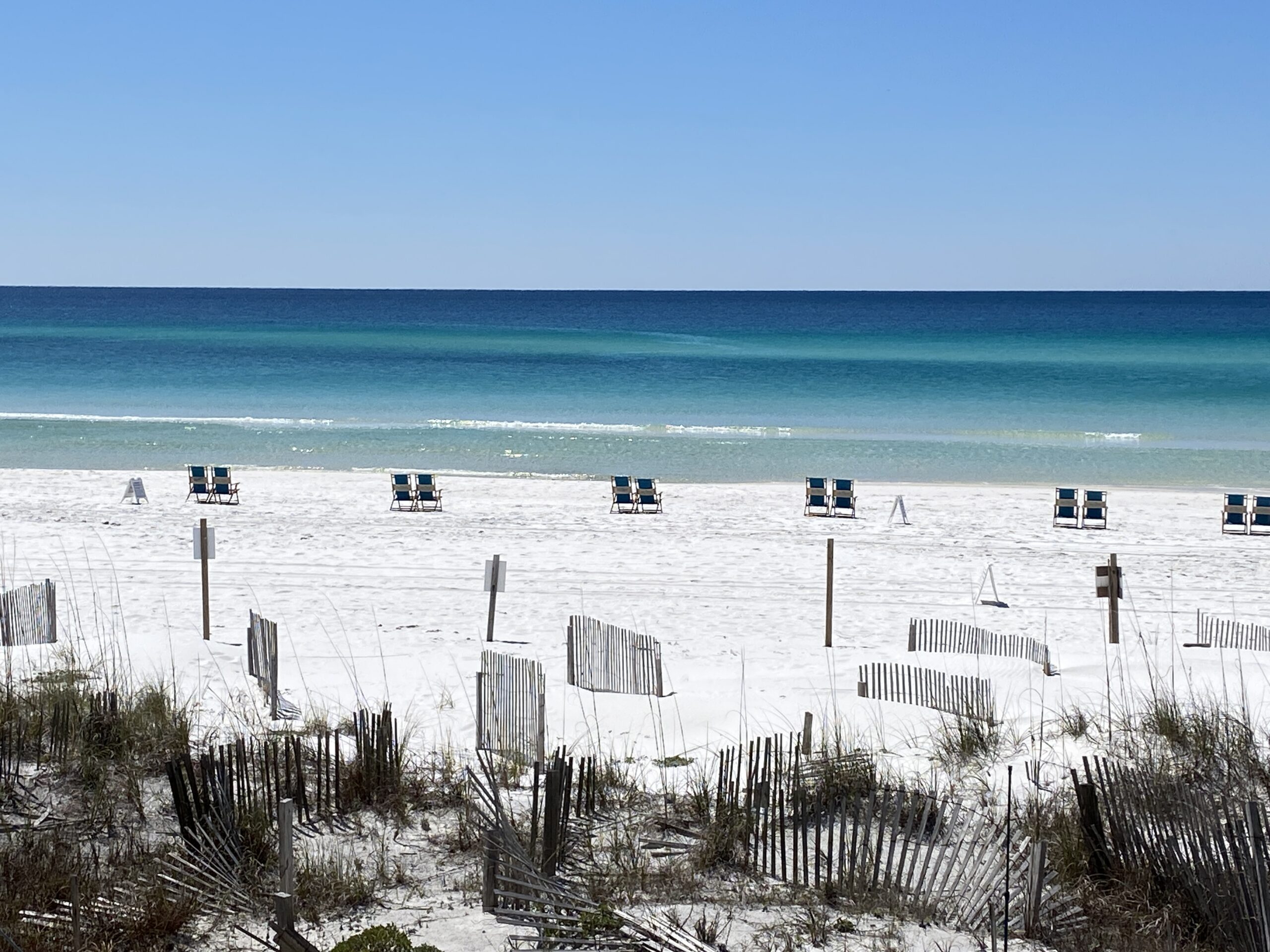 The backyard at Leeward Unit 2 — chairs set up, Gulf straight ahead