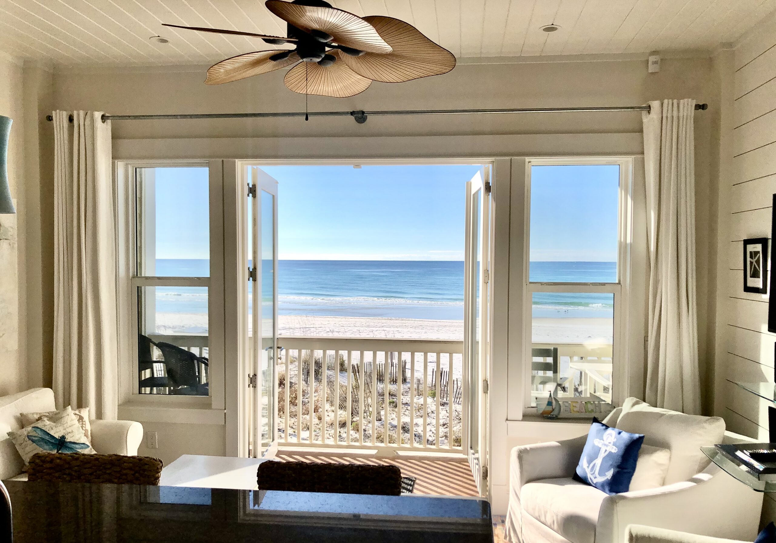 The view from inside Leeward Unit 2 — open doors framing the beach and Gulf of Mexico, Seagrove Beach on 30A